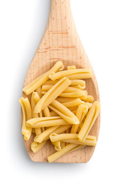 uncooked pasta caserecce in wooden spoon