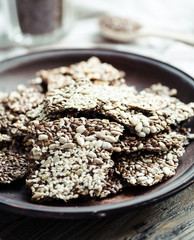 crackers from flax seed, sesame, sunflower and spices on a dark