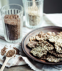 crackers from flax seed, sesame, sunflower and spices on a dark