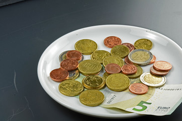Münzen auf Teller