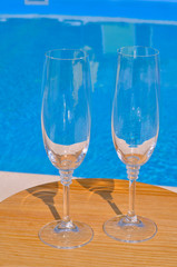 Two clean glasses on background of pool