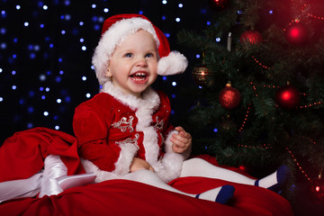 Fototapeta na wymiar Happy baby in a Christmas santa costume