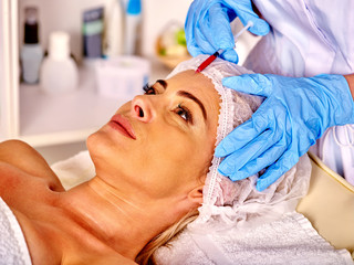 Fototapeta na wymiar Woman middle-aged in spa salon with beautician. Female giving botox injections