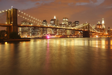 Naklejka na ściany i meble The Brooklyn Bridge and Manhattan skyline as seen from across the East River at dusk.