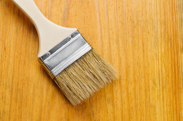 Paint brush on varnished wooden board with place for text