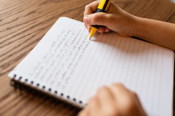 Person writing by hand on notepad