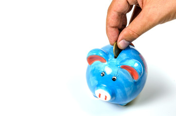 Man hand inserting a coin in a piggy bank. Saving money concept