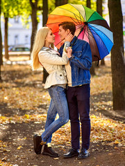Loving couple on a date under umbrella.