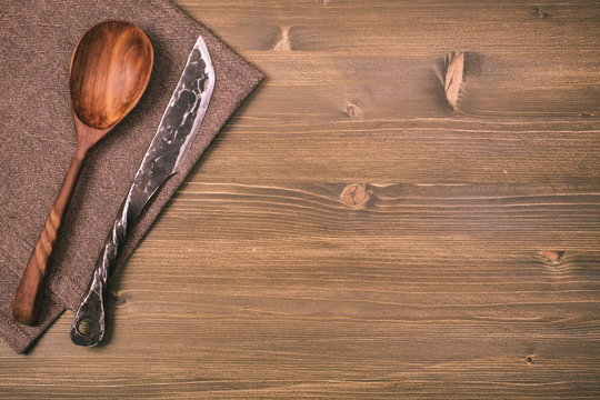 Rustic knife and spoon on wooden background