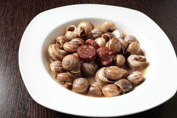 white dish with snails cooked in sauce