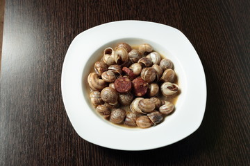 white dish with snails cooked in sauce