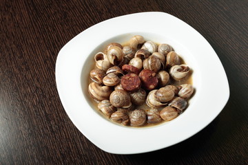 white dish with snails cooked in sauce