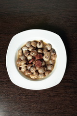 white dish with snails cooked in sauce