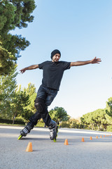 Urban young man on roller skates on the road at summer time