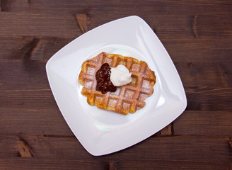 waffles with chocolate cream on wooden table seen from above