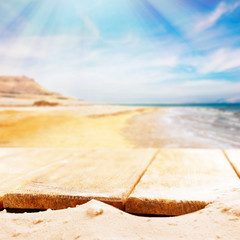 Sand with wooden planks on sea background