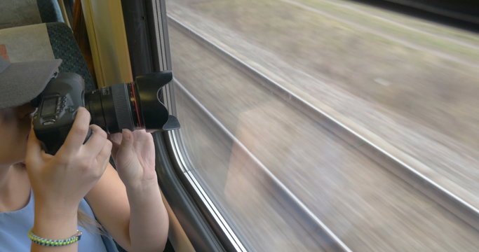 Young girl going by train and taking pictures.