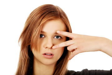Fototapeta premium Teenage woman with victory sign on eye