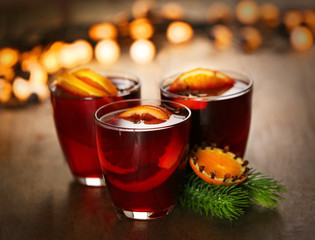 Mulled wine with spices and Christmas tree on wooden background