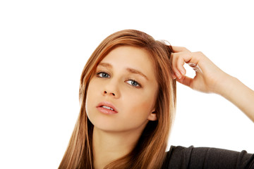 Fototapeta premium Pensive teenage woman scratching her head