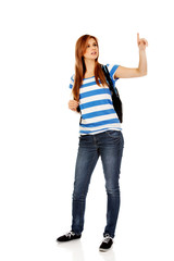 Teenager woman with backpack pointing for soomething