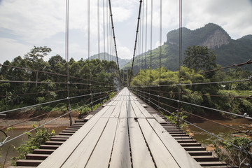 Obraz premium Suspension bridge over the river in Ratchaprapa Dam