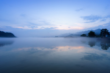 lake, hill and reflection in fog