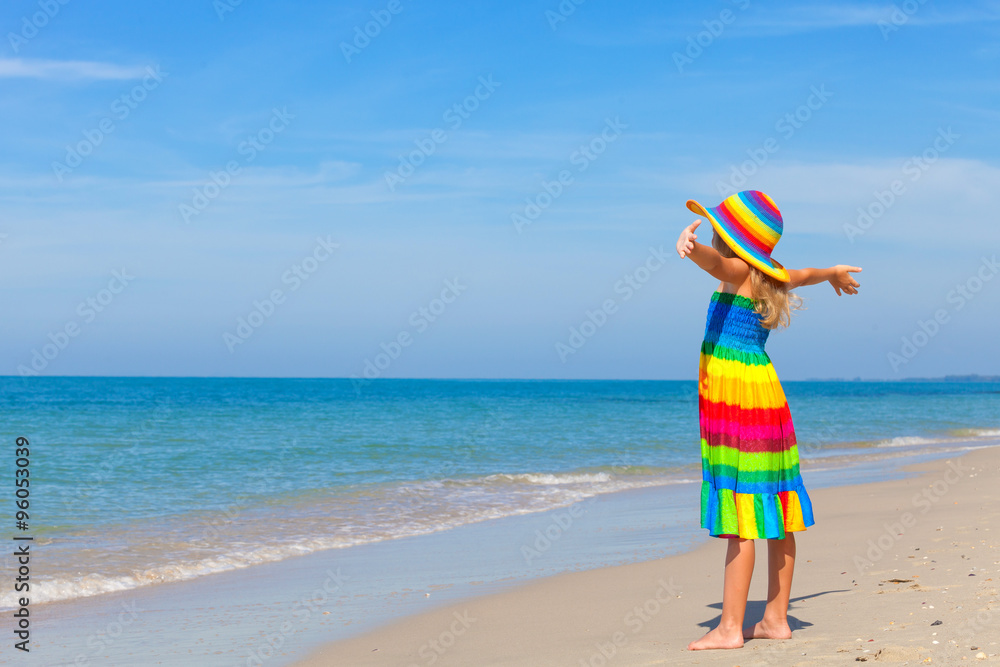 Wall mural little girl standing on the beach