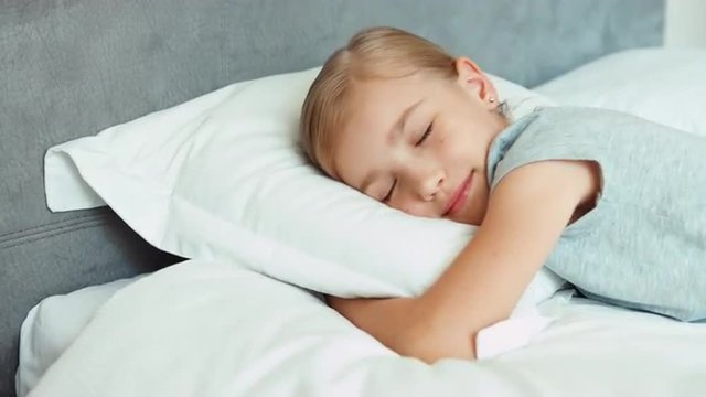 Girl sleeping in a bed and smiling