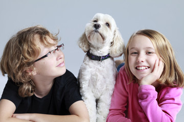 Studio portrait of a boy and girl with their dog.