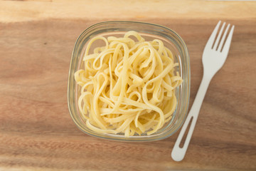 a small portion of linguini pasta in a glass storage container
