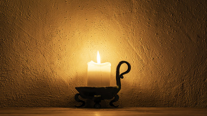 burning candle on a background of textured walls
