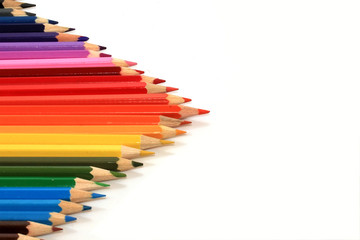 много цветных карандашей в виде треугольной стрелки на белом фоне