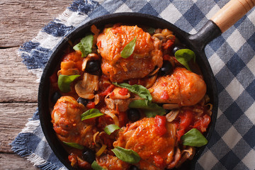 Cacciatori Chicken with black olives close-up in a pan. horizontal top view
