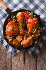 Cacciatori Chicken with mushrooms and olives in a pan. vertical top view
