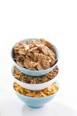 assortment of breakfast cereal in bowls, isolated, vertical