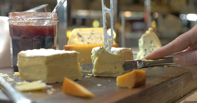 Hands Cutting Soft Cheese with Knife