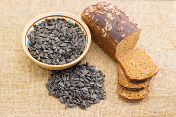 Brown bread and sunflower seeds on the sackcloth