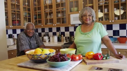 Black senior couple smiling at camera in kitchen - Powered by Adobe