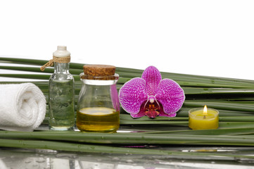 Obraz na płótnie Canvas orchid with candle ,massage oil, towel and set of green leaf 