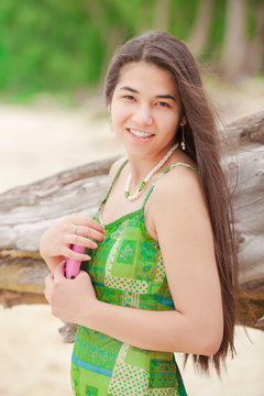 Beautiful teen girl holding cellphone , smiling on Hawaiian beac