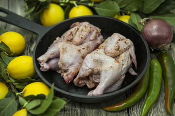 Three fresh raw chicken on a wooden tray with lemon and chilli  on the wooden background