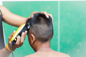 little boy getting his head shaved by farther