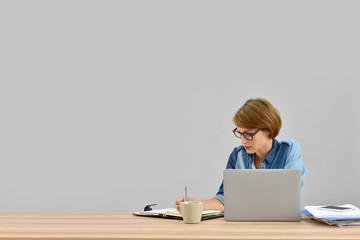 Businesswoman working on laptop, isolated