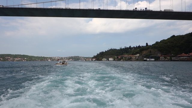 Passing under Fatih Sultan Mehmet Suspension Bridge over the Bosphorus Strait in Istanbul Turkey. Shot from a touristic boat.