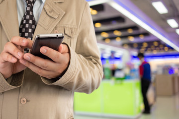 Man in shopping mall using mobile phone.