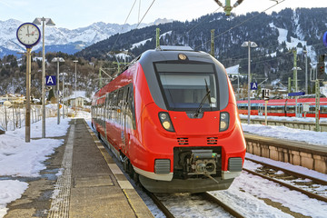 Shiny red train stopped at the Germany, Garmisch-Partenkirchen railway station