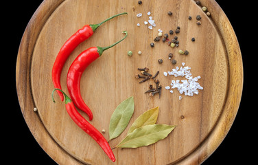 Herbs and spices on wooden board. Chili, salt, pepper, bay leaf,