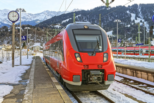 Fototapeta Shiny red train stopped at the Germany, Garmisch-Partenkirchen railway station