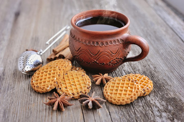 Fototapeta na wymiar A cup of hot tea with cookies on a rustic wooden background